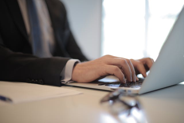 person writing on their laptop